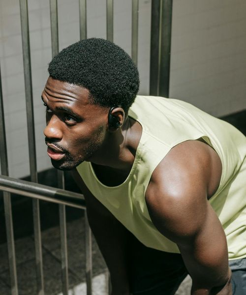 Man performing a controlled strength exercise in a modern gym.